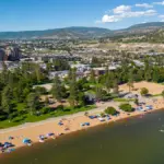 Panoramic hillside and lake view beside modern homes under a clear sky